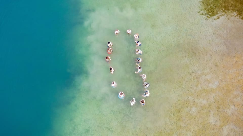 Luftaufnahme einer Gruppe in einer Kreisformation im Wasser