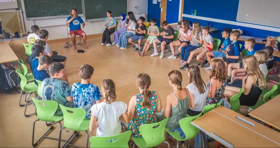Kinder sitzen gemeinsam im Sesselkreis