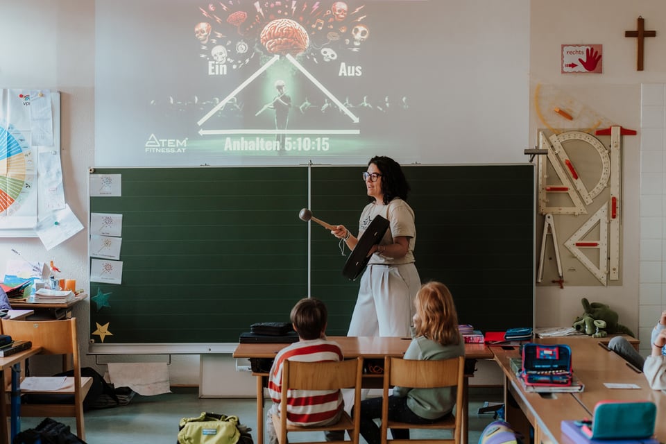 Trainerin erklärt ein Diagramm an der Schultafel