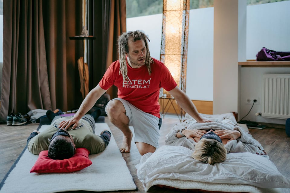 Daniel Fetz begleitet zwei liegende Teilnehmende bei einer Atemsession