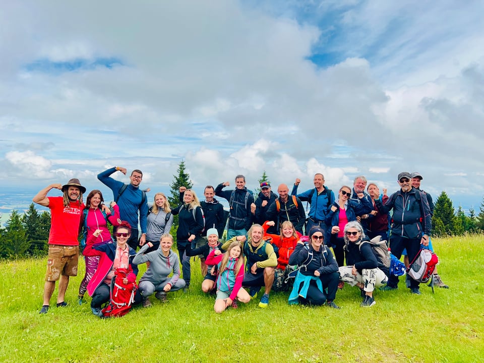 Atemfitness Gruppe versammelt sich auf einer weiten Bergwiese