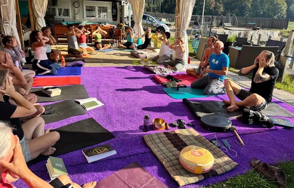 Atemfitness Gruppe übt sitzend unter dem offenen Zeltdach am Salmsee