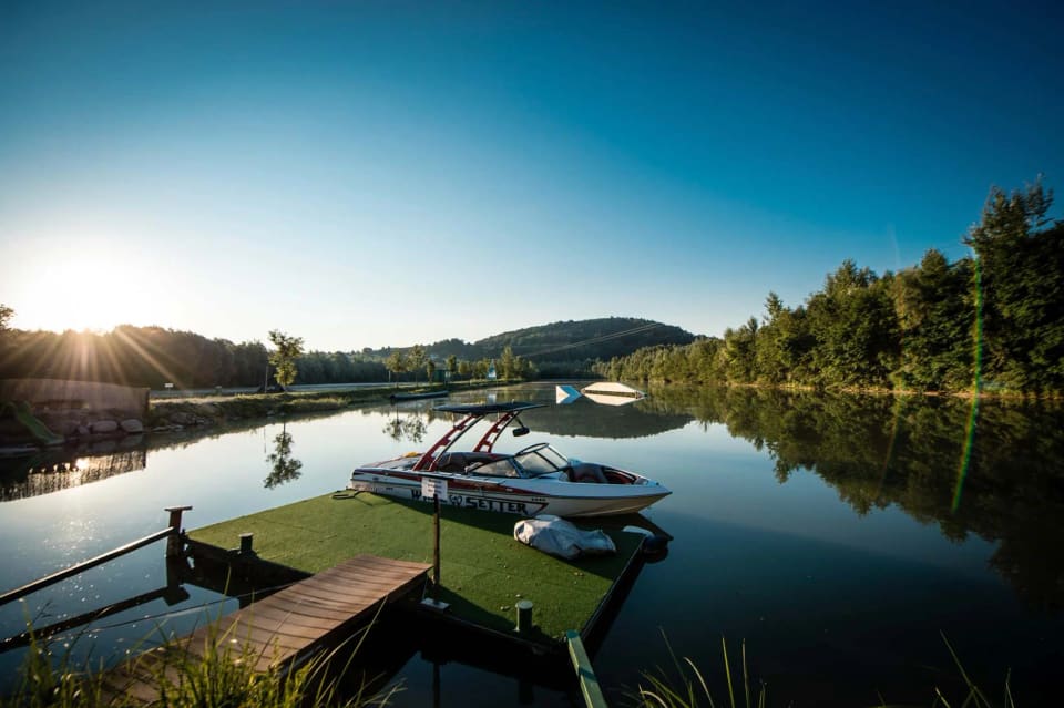 Motorboot am Steg des ruhigen Salmsees im Morgenlicht