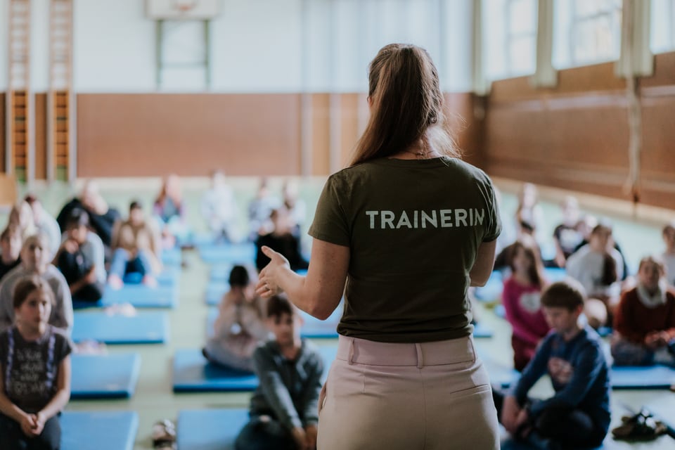 Trainerin begleitet eine große Schulgruppe