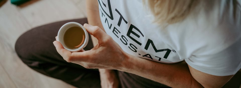 Frau hält nach einer Atemfitness® Einheit eine Tasse Tee